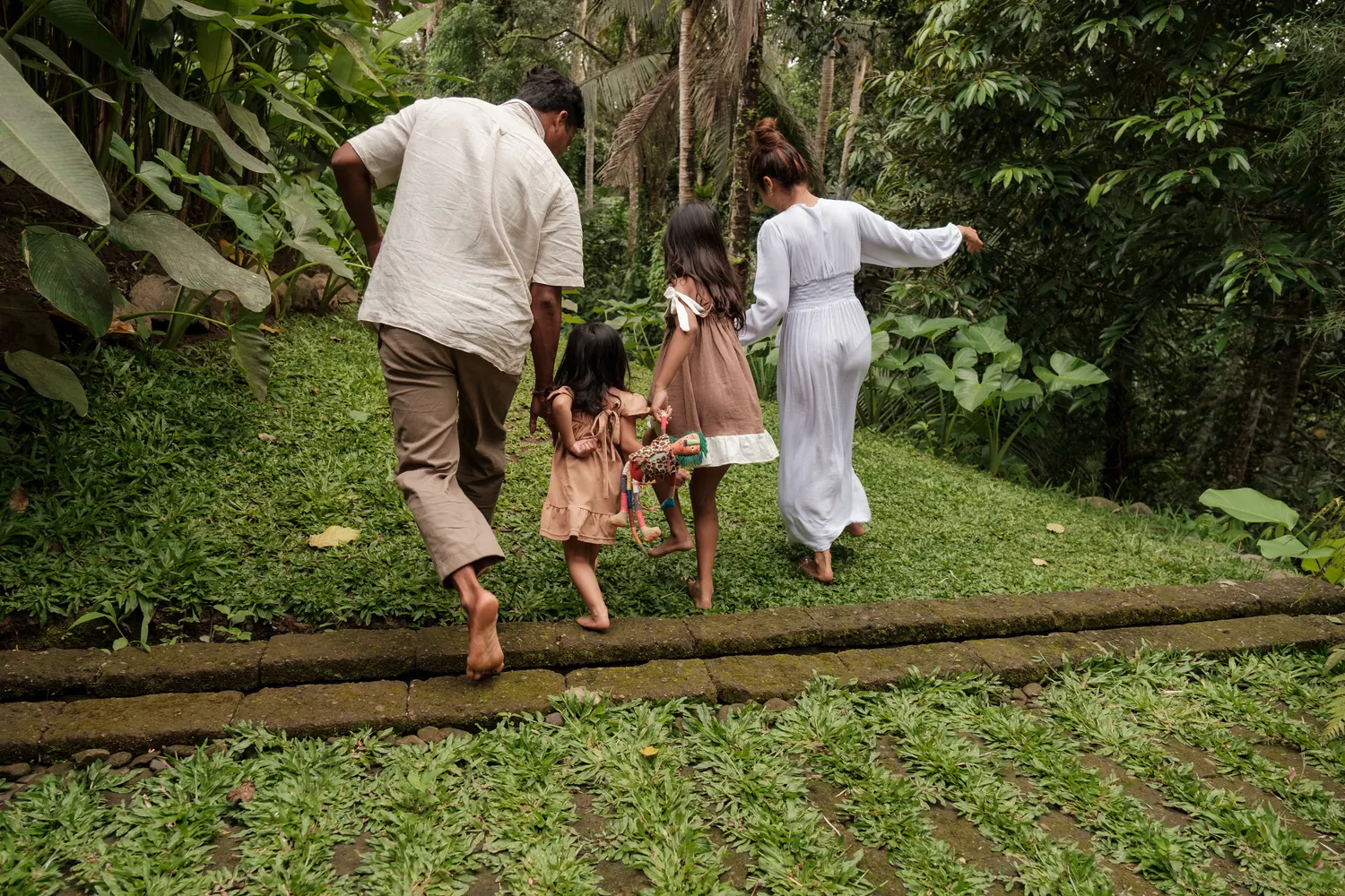 Family with children walking through a tropical garden
